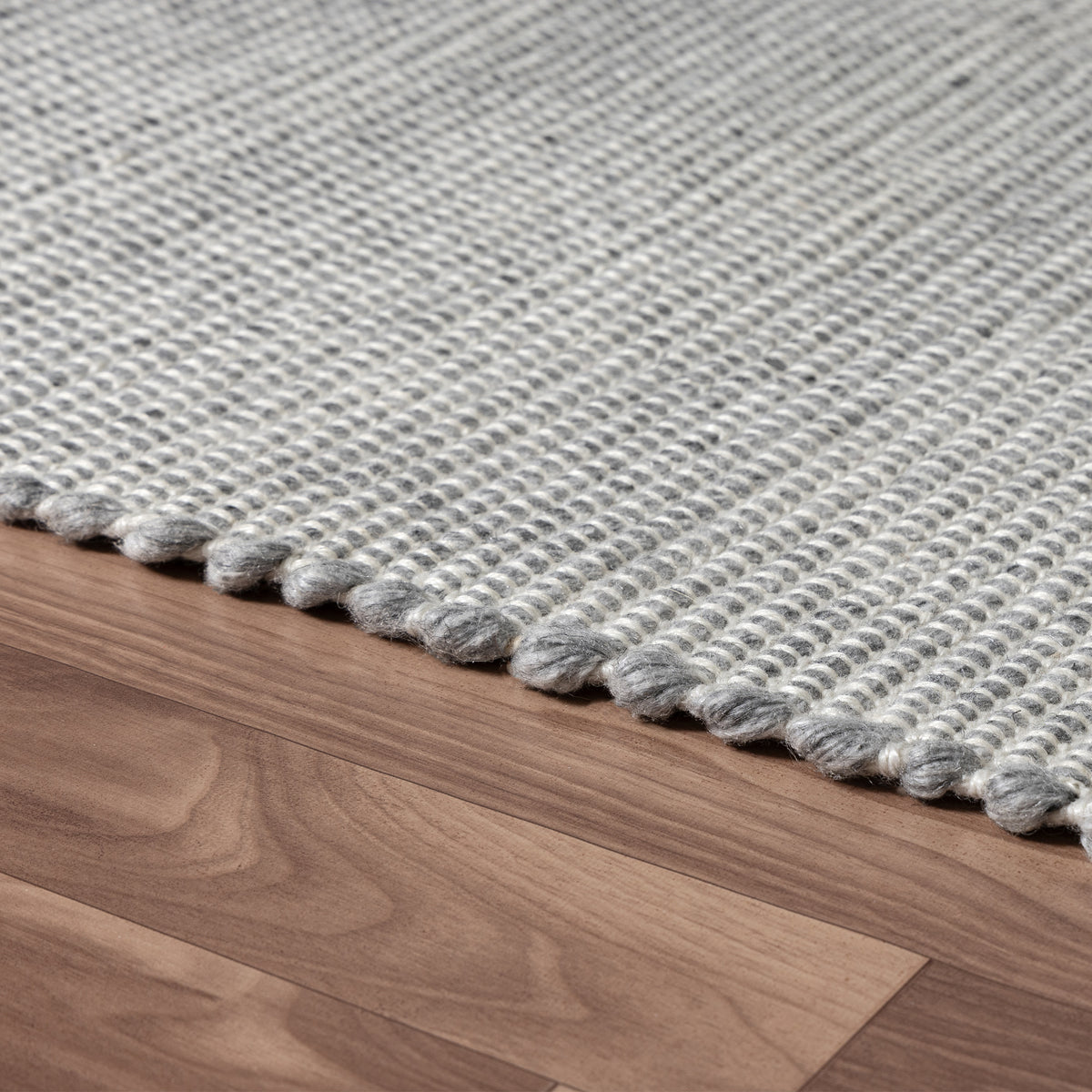 Gray/Ivory Contemporary Solid Hand-Woven Polyester Indoor Area Rug - side angle view